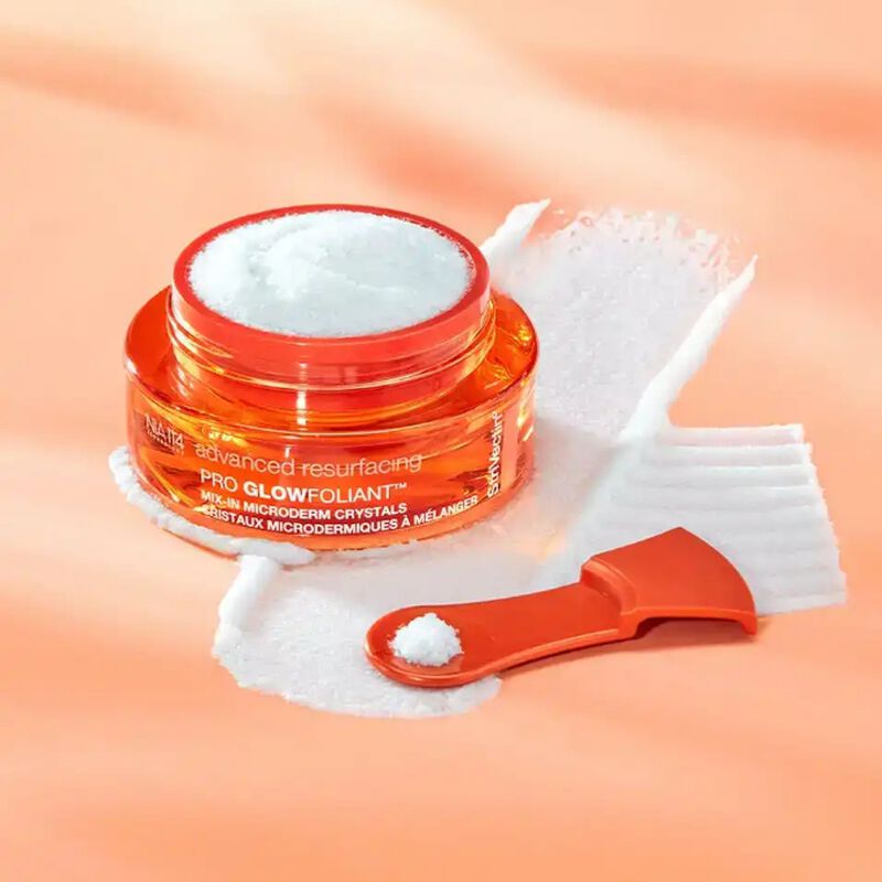 Open jar of Pro Glowfoliant™ Mix-In Microderm Crystals with spatula